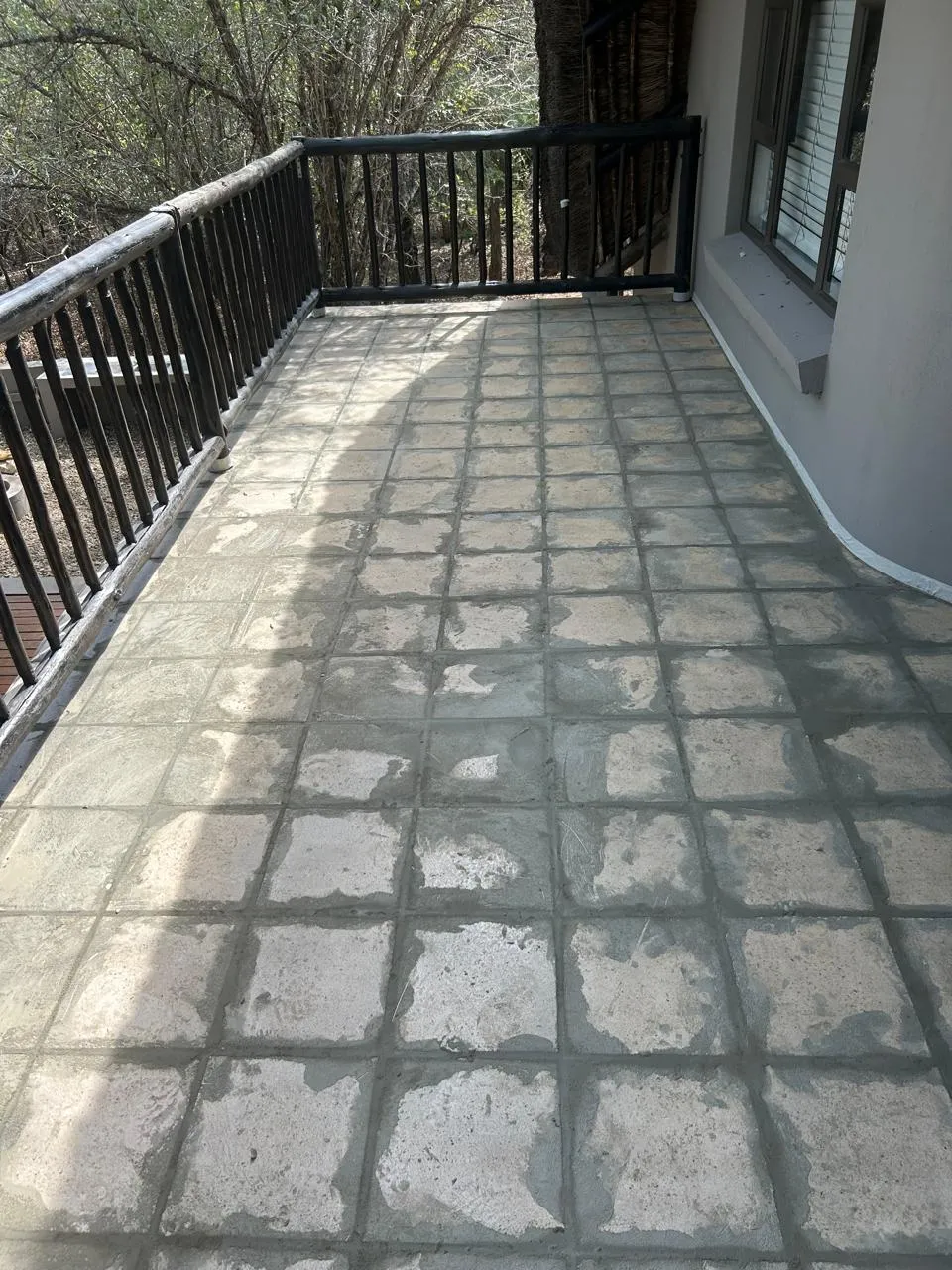 Balcony with worn, stained square tiles