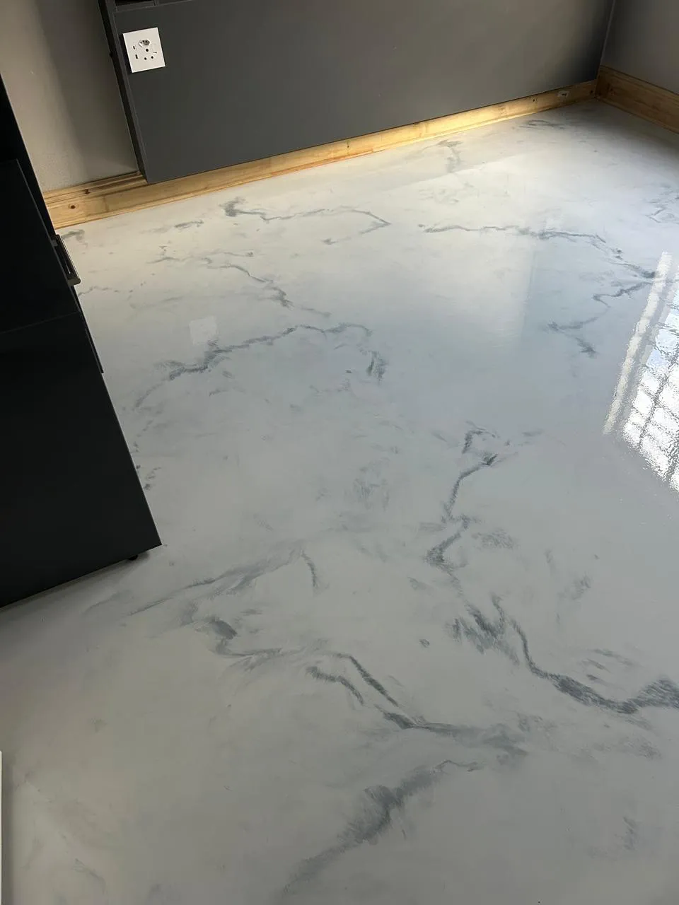 Room with a glossy white marble epoxy floor with grey veining